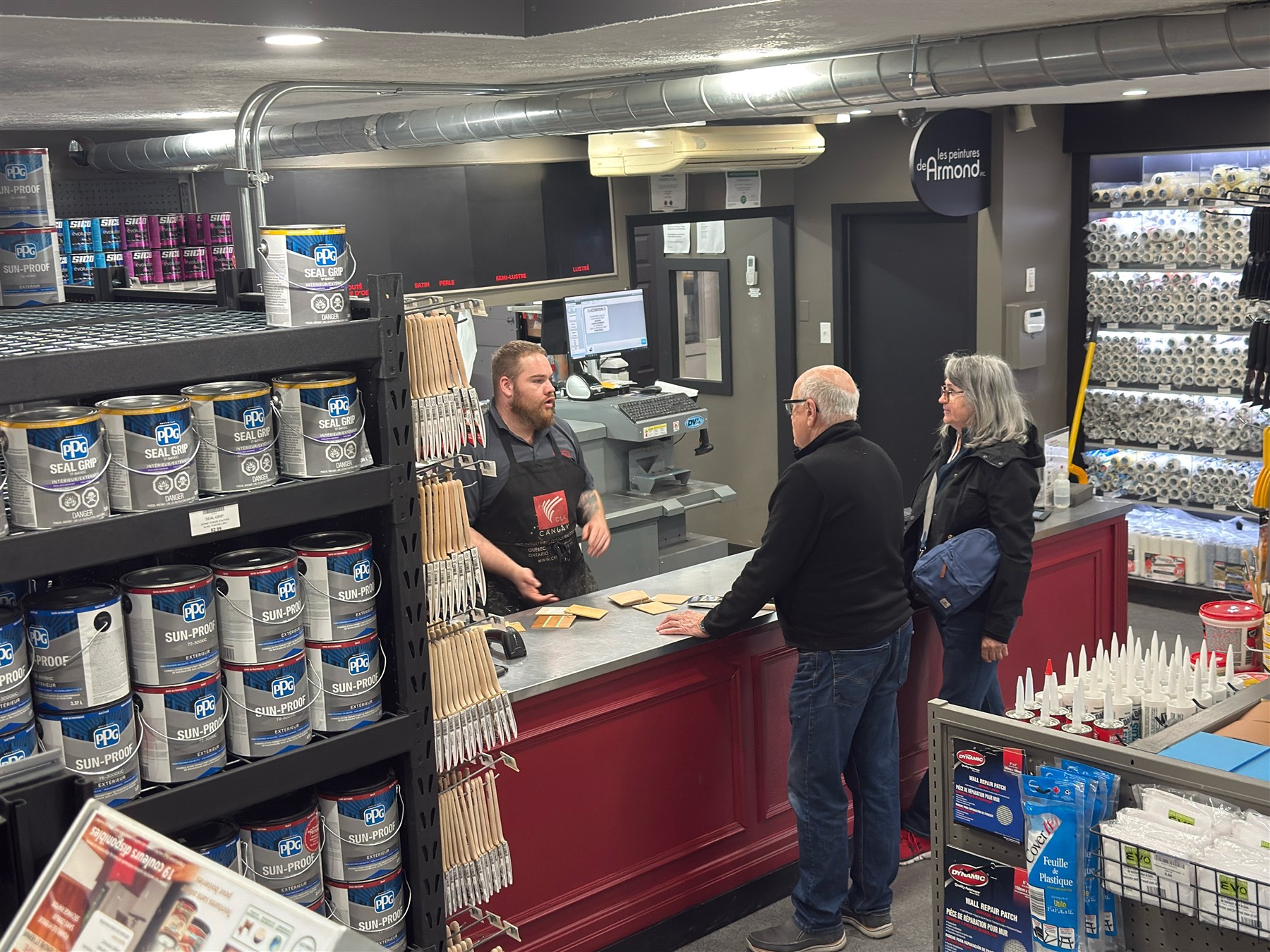 Un membre de notre équipe conseille des clients au comptoir du magasin.